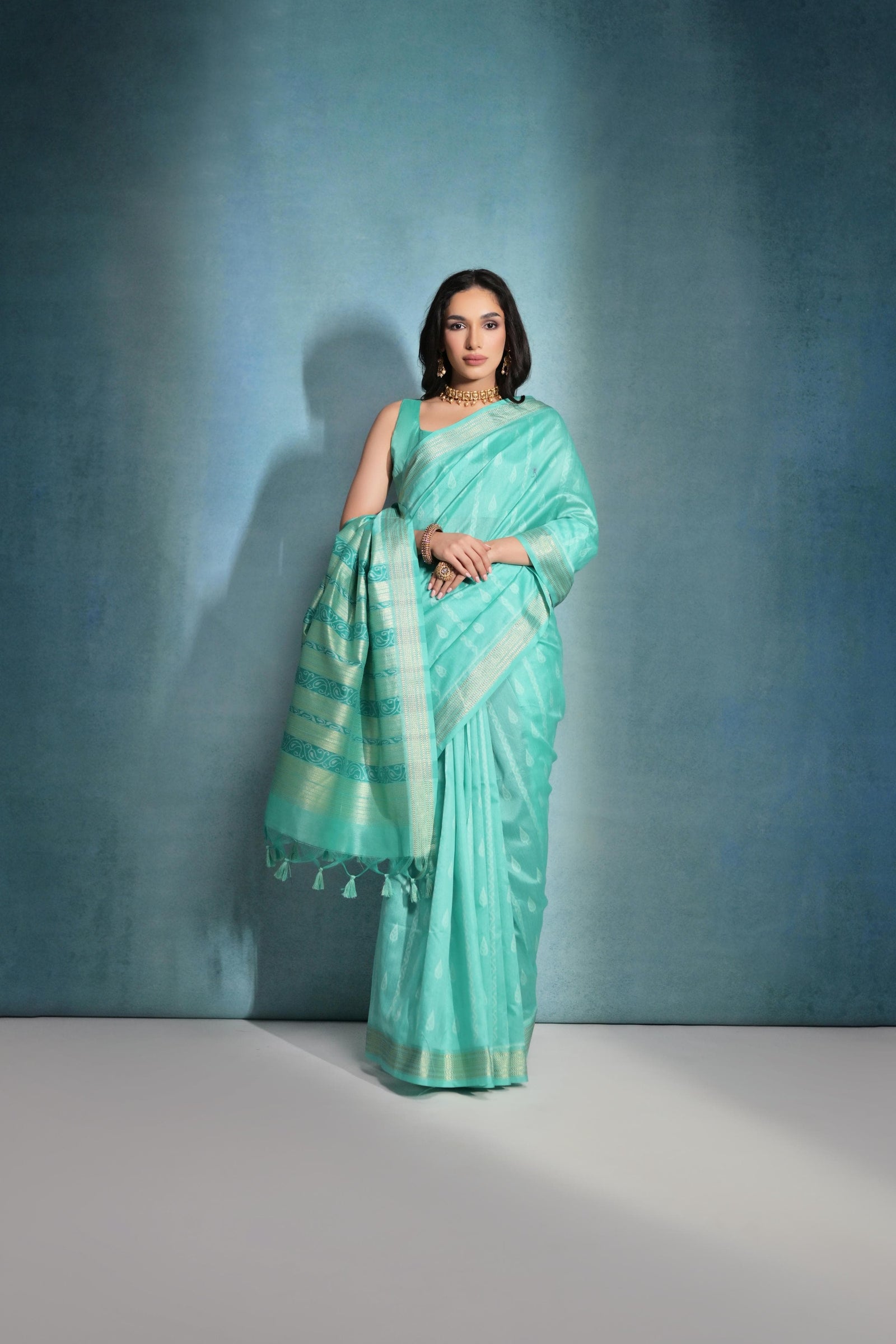 Light teal saree featuring intricate ikkat and zari weaving, showcasing traditional handloom textile craftsmanship