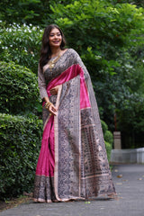 Woman wearing traditional dark pink Madhubani print saree with intricate designs and ethnic jewelry in a green outdoor setting