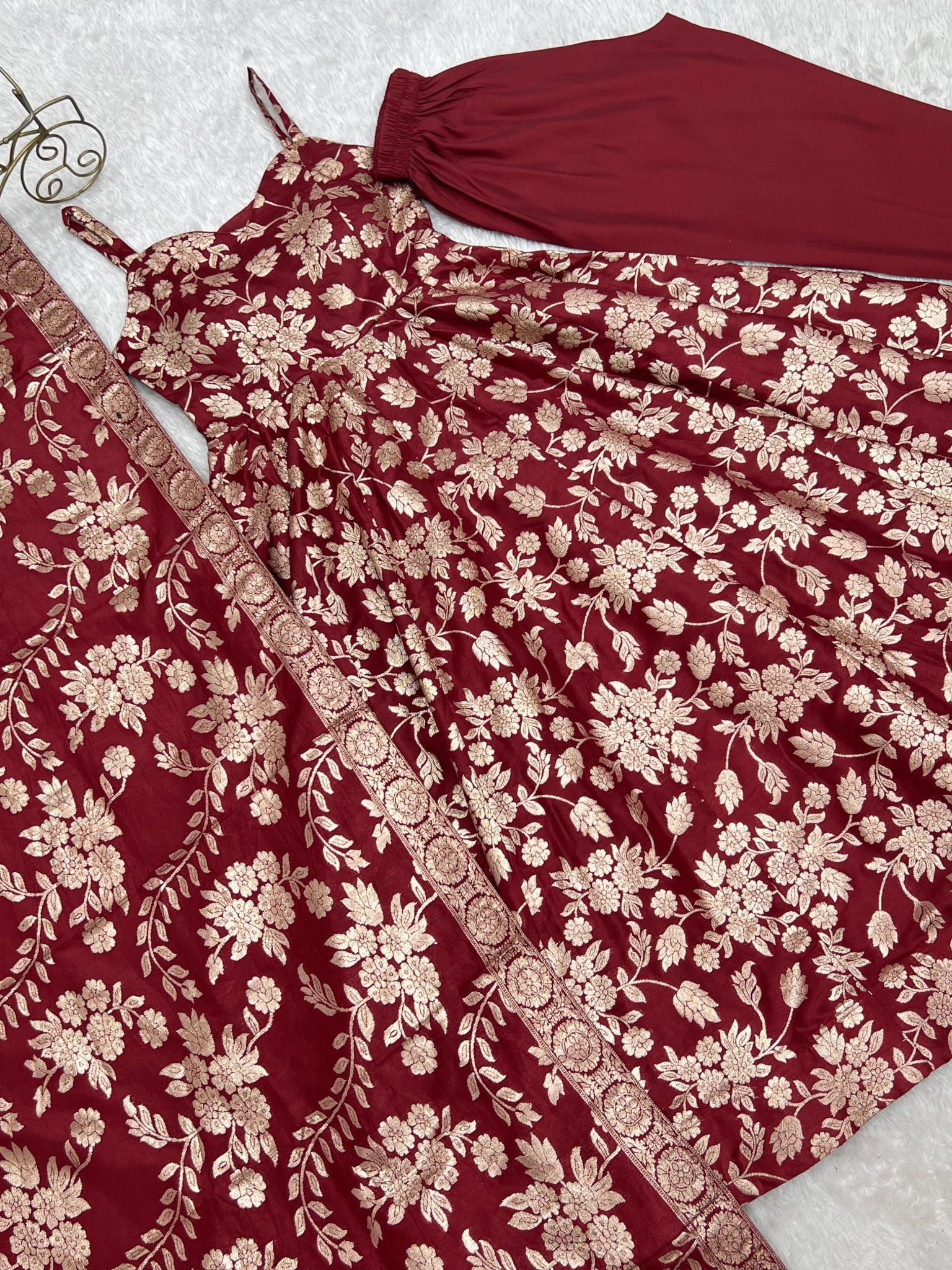 Flat lay of maroon Banarasi jacquard Anarkali suit with zari border