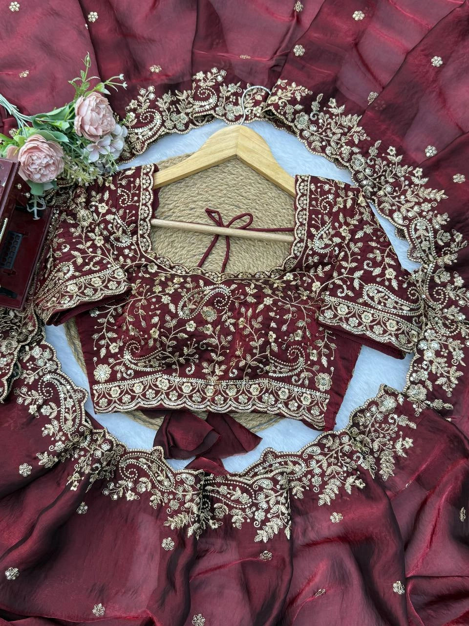 Maroon saree flat lay with embroidered blouse piece