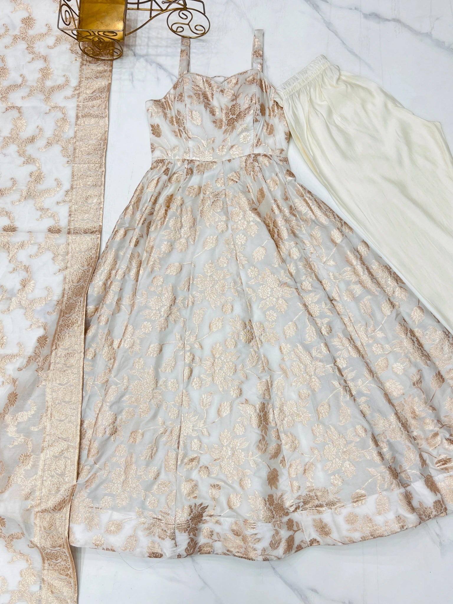 Flat lay of Off White Banarasi jacquard Anarkali suit with zari border