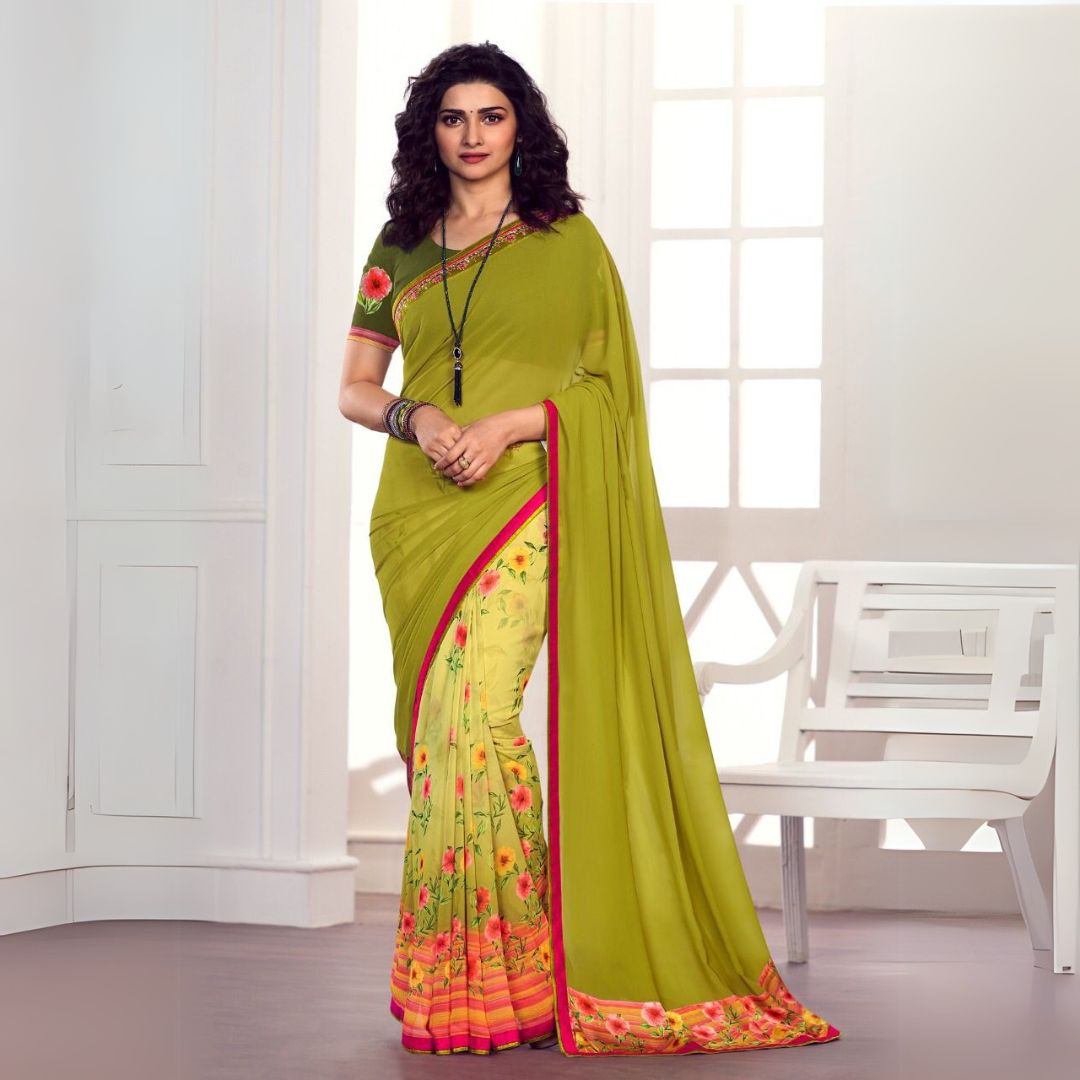 Woman wearing olive green printed saree with floral patterns and pink border in a traditional indoor setting