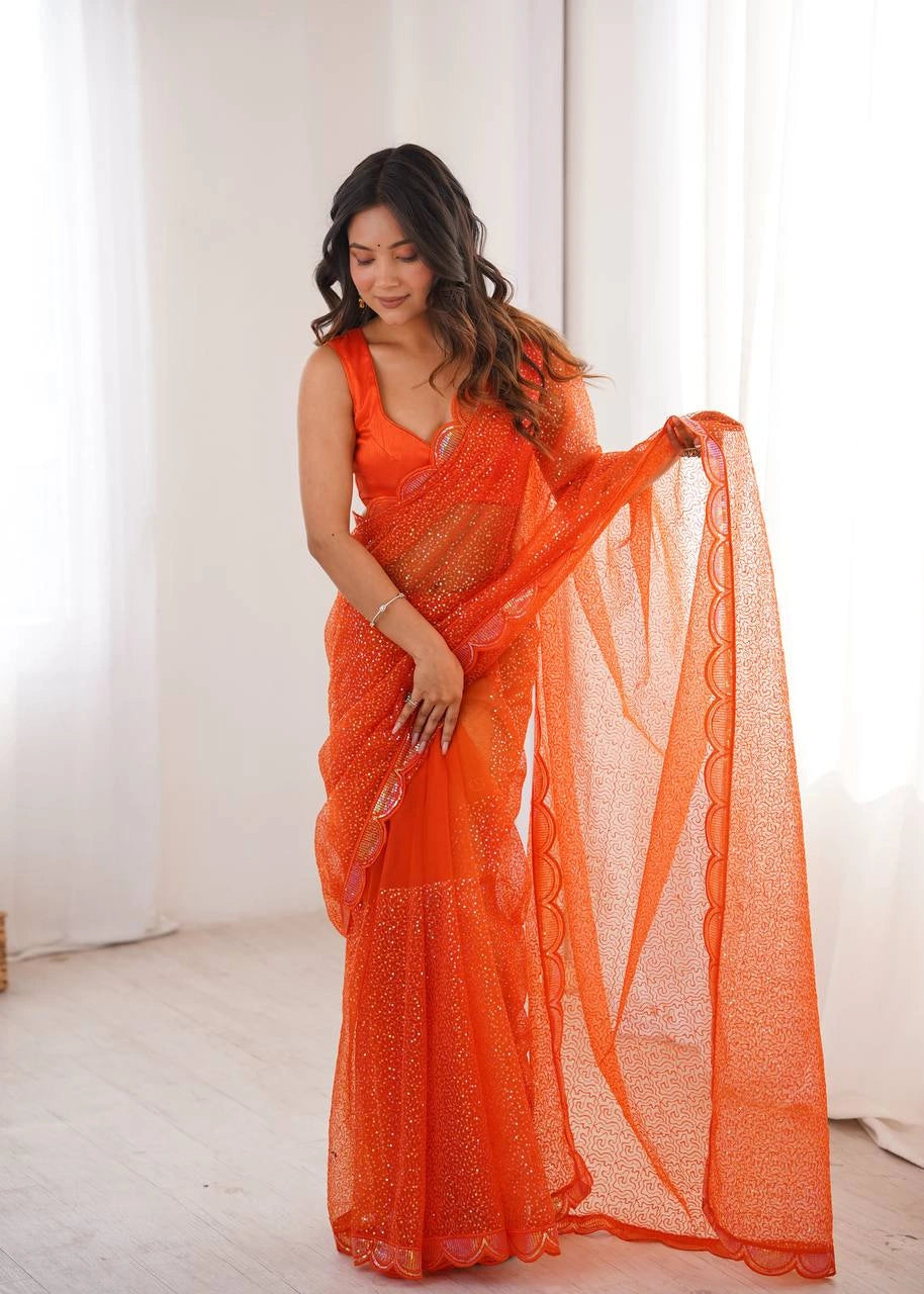 Orange net saree with scalloped border – model pose