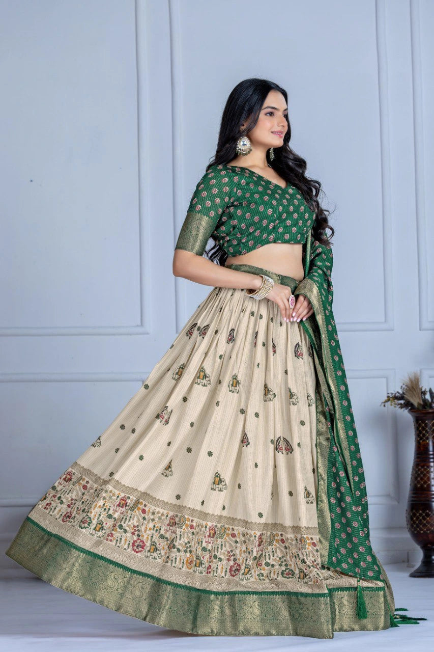 Woman wearing a traditional green and beige saree with a white wall background
