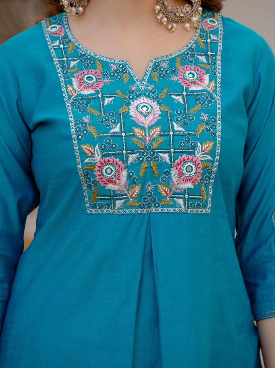 Teal blue kurta with floral embroidery on a plain background