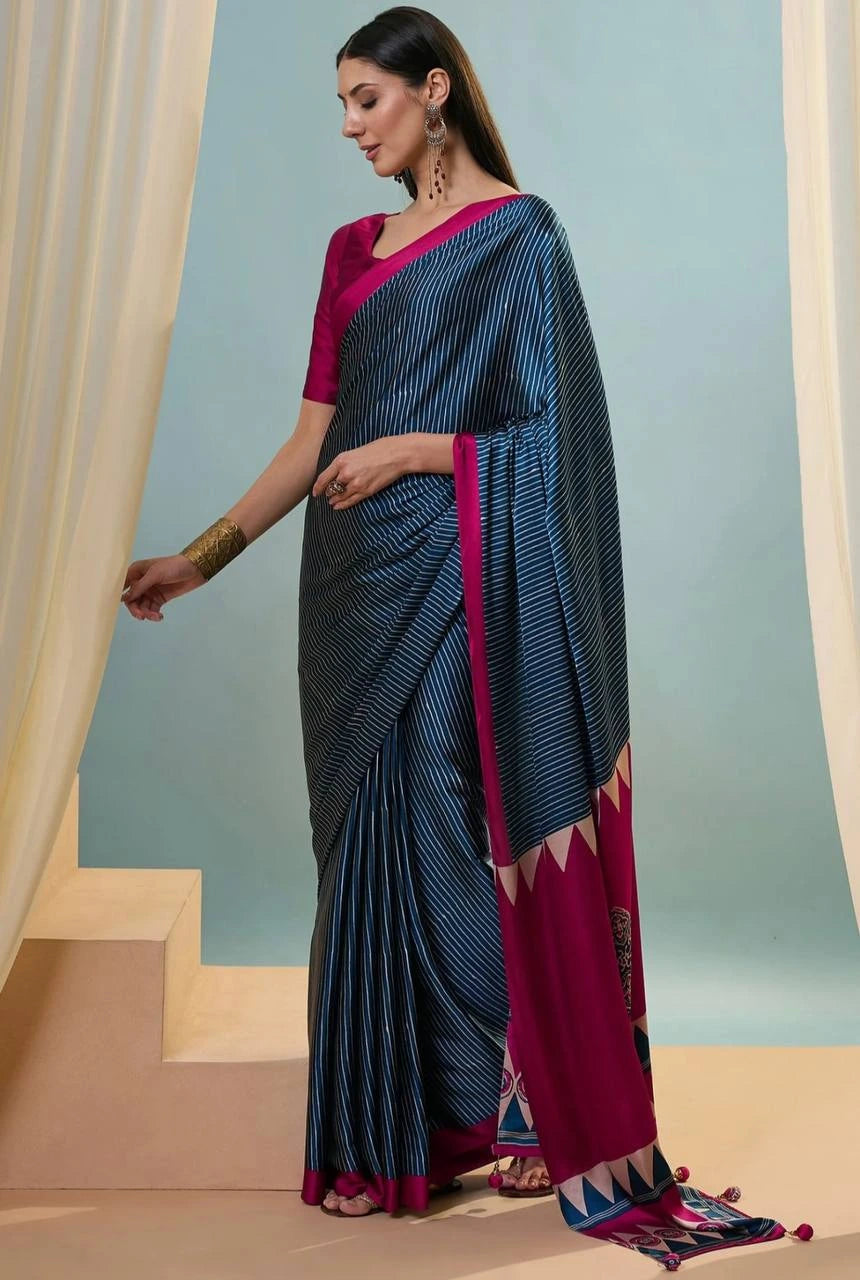 Woman wearing a blue and pink saree with a plain background
