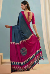 Woman wearing a pink and blue saree with a geometric pattern against a light blue background