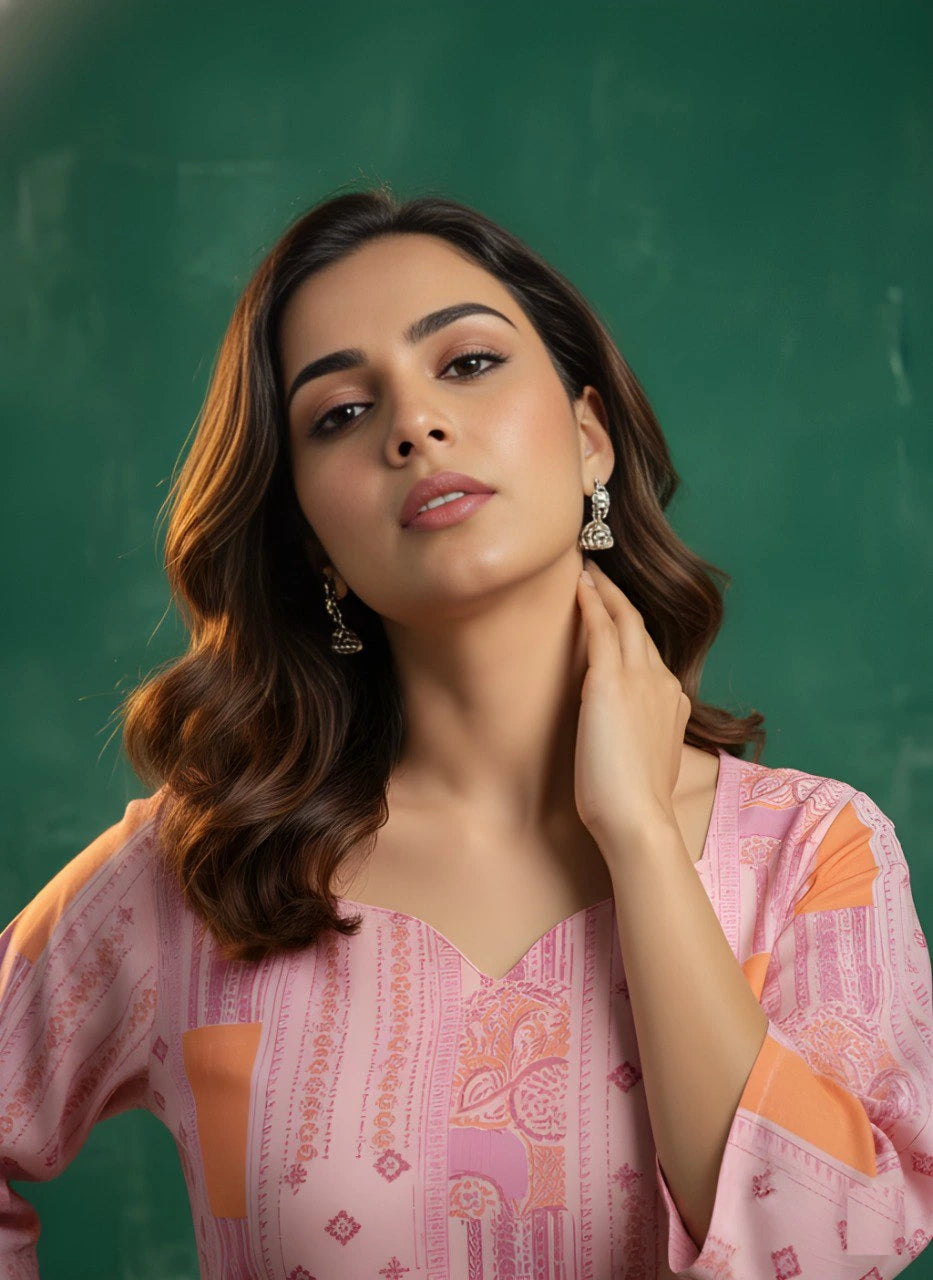 Woman in a pink and orange patterned top against a green chalkboard background