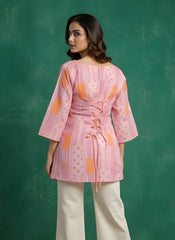 Woman wearing a pink patterned top with a green background