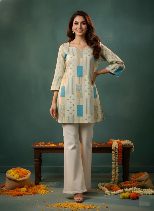 Woman wearing a patterned kurta with white pants against a green background