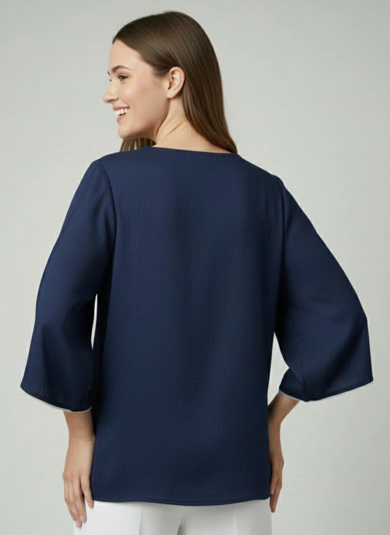 Woman wearing a navy blue blouse with a plain background