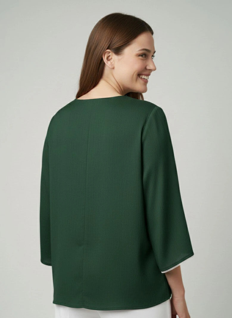 Woman wearing a green blouse against a plain background