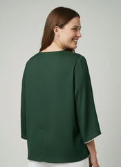 Woman wearing a green blouse against a plain background