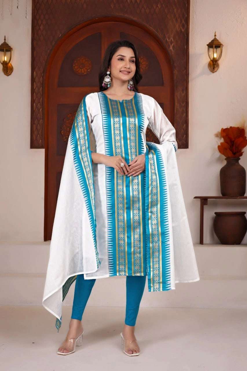 Woman wearing a white and blue traditional outfit with a decorative dupatta in an indoor setting.
