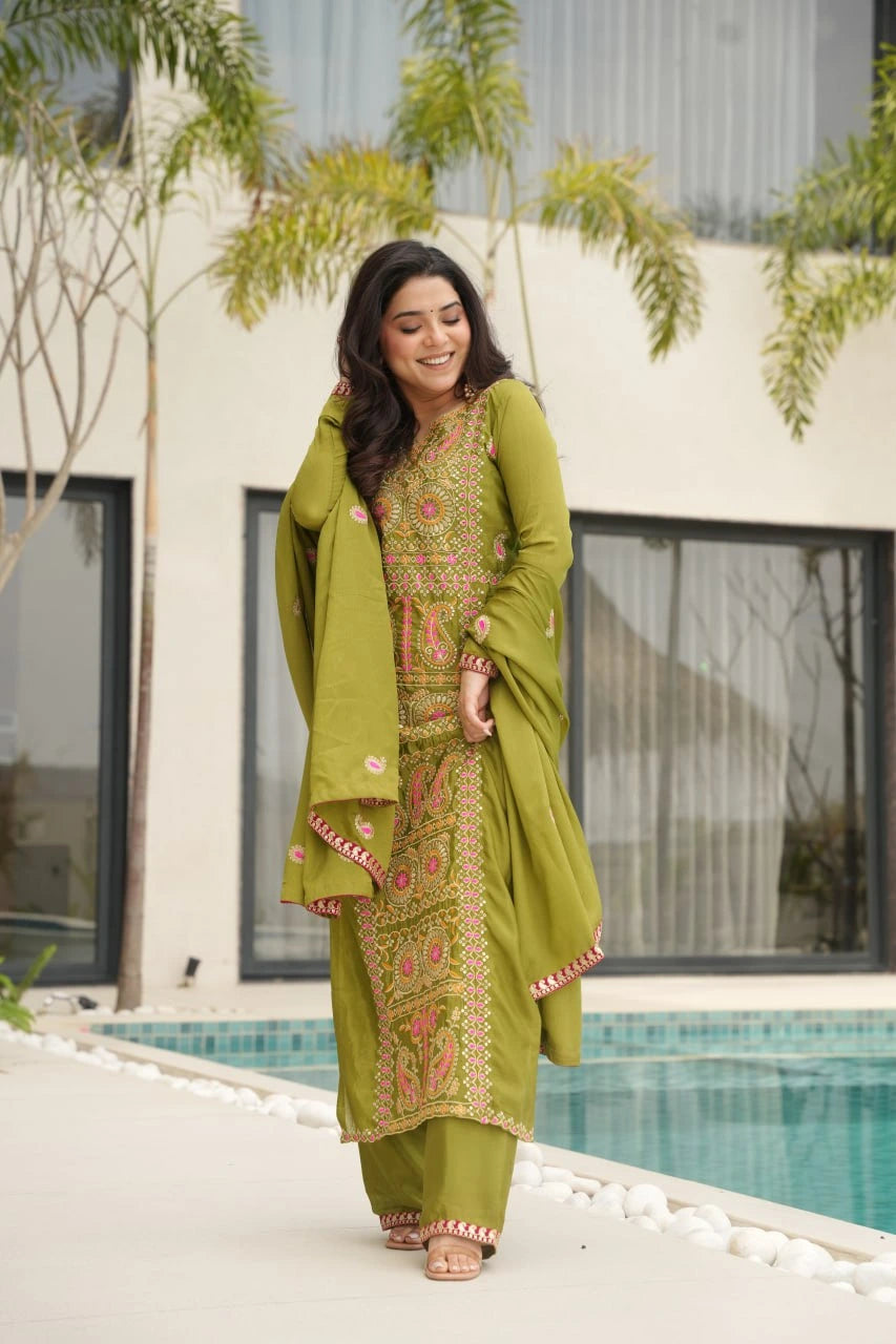 Woman in a green traditional outfit standing by a poolside.