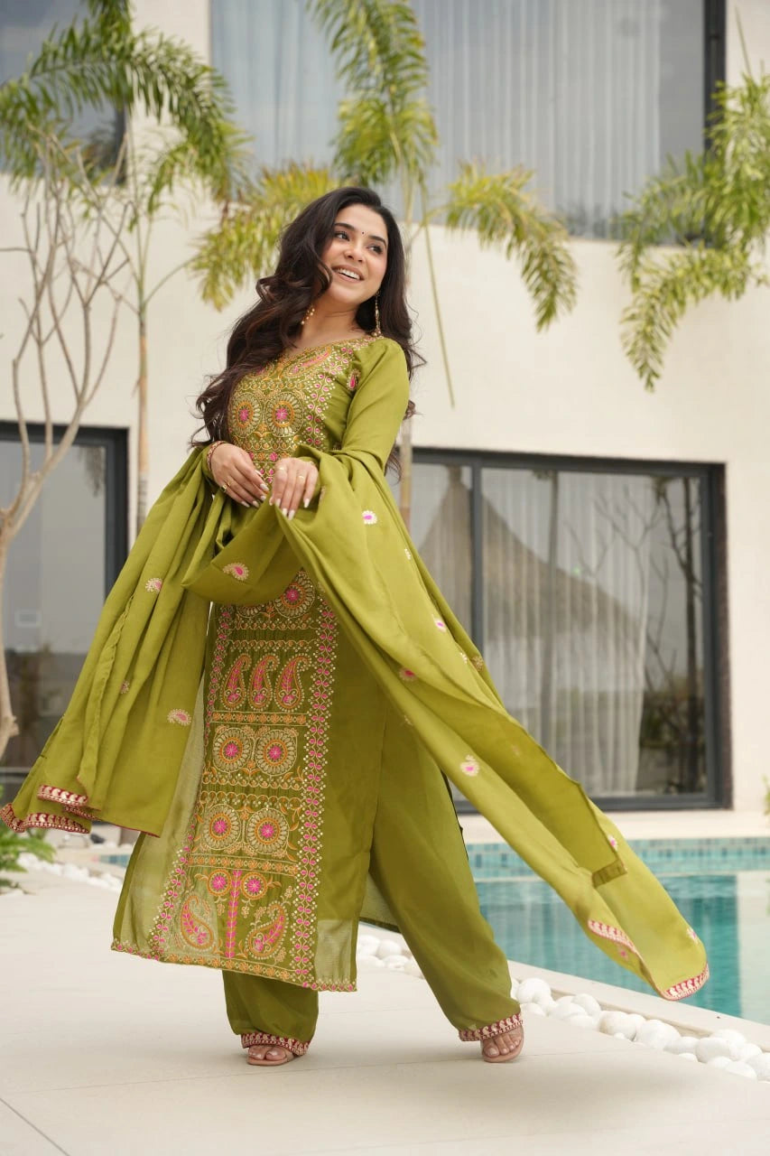 Woman in a green traditional outfit with embroidery by a poolside.