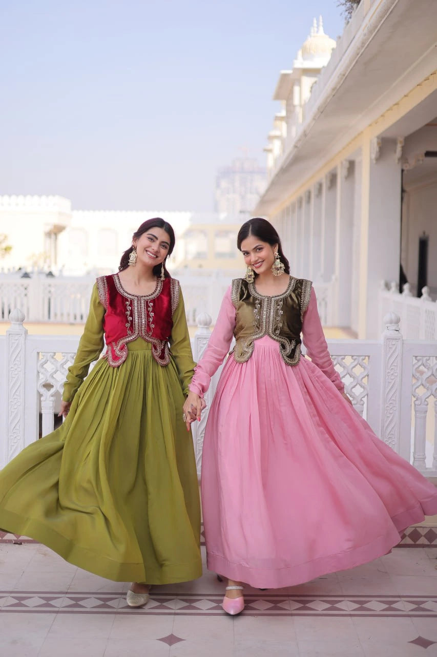 Two women in traditional dresses standing on a balcony with a building in the background.