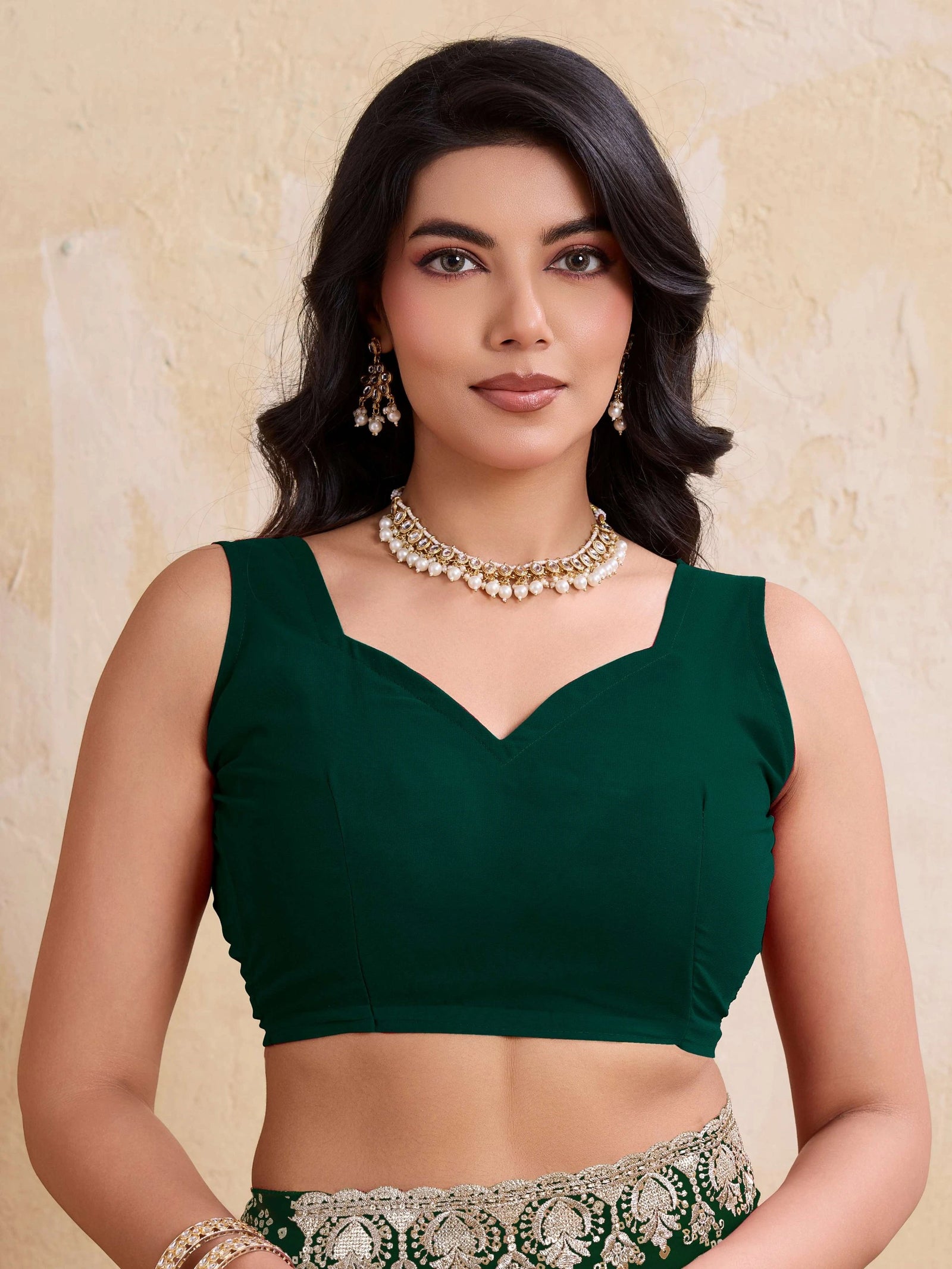 Woman wearing a green blouse with a beige background