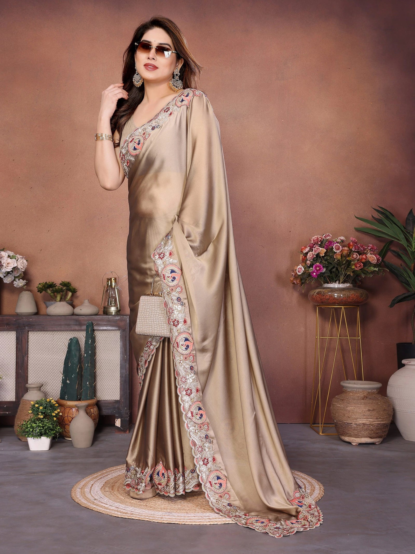 Woman in a beige saree with floral patterns in an indoor setting