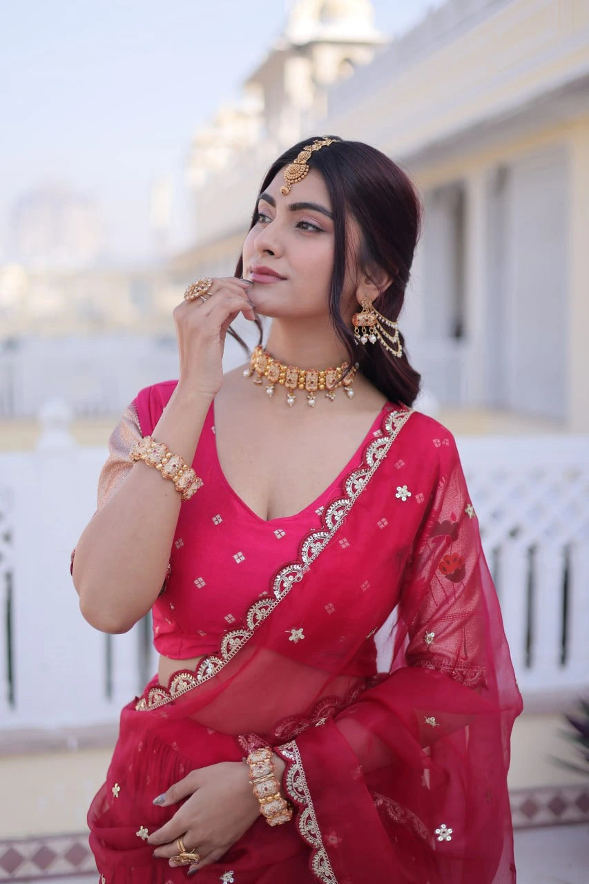 Woman in a red saree with gold jewelry outdoors