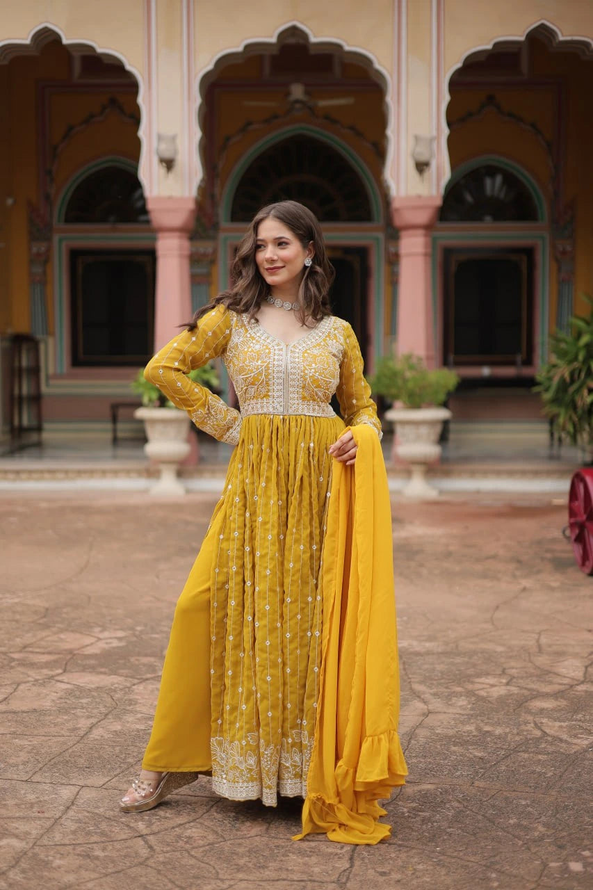 Woman in a yellow traditional outfit standing in front of an architectural building.