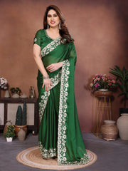 Woman wearing a green saree with floral patterns in a decorated indoor setting