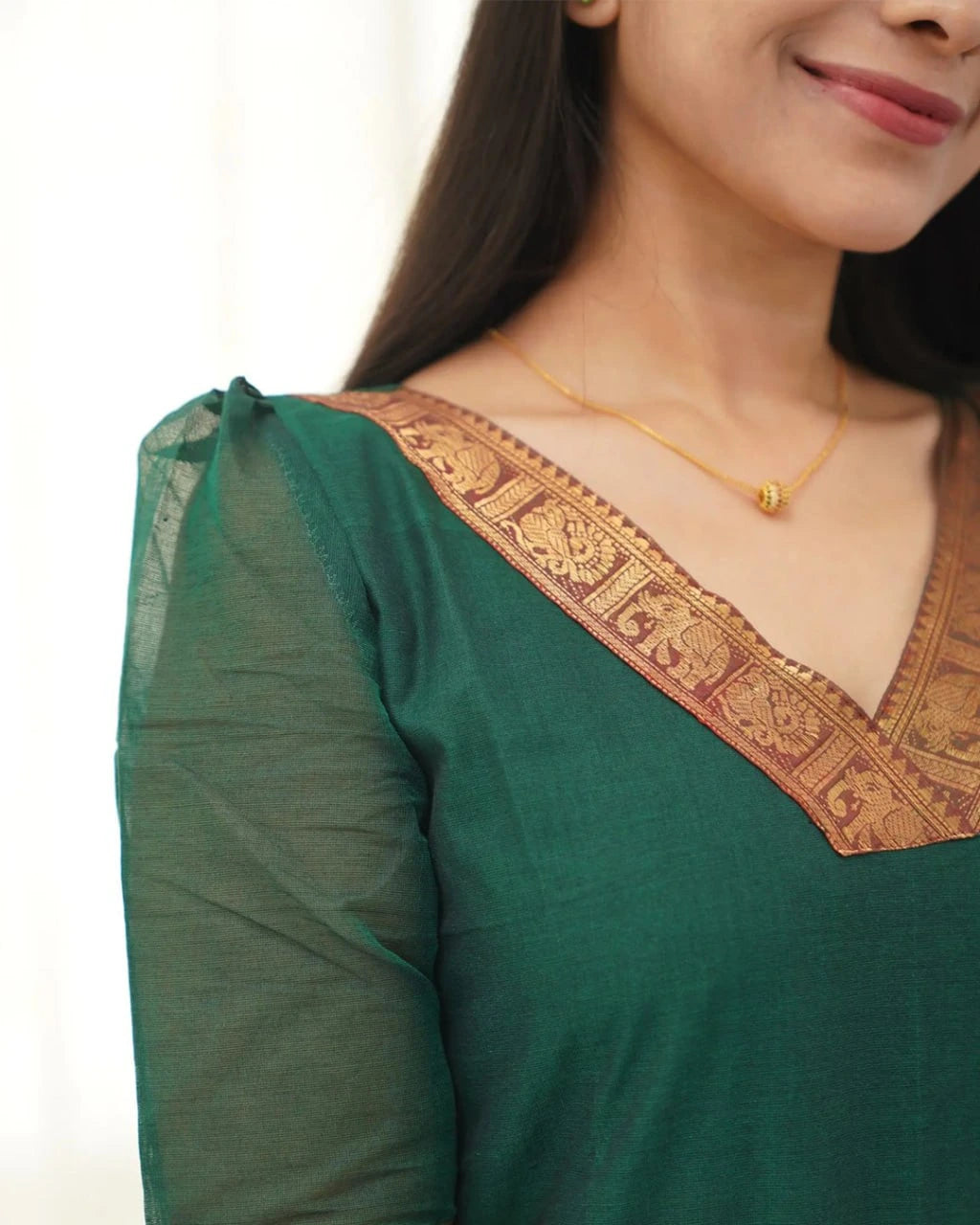 Green traditional outfit with gold embroidery on a white background