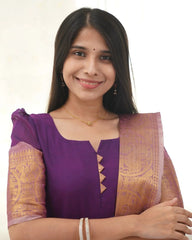 Woman wearing a purple blouse with a gold and purple saree on a white background