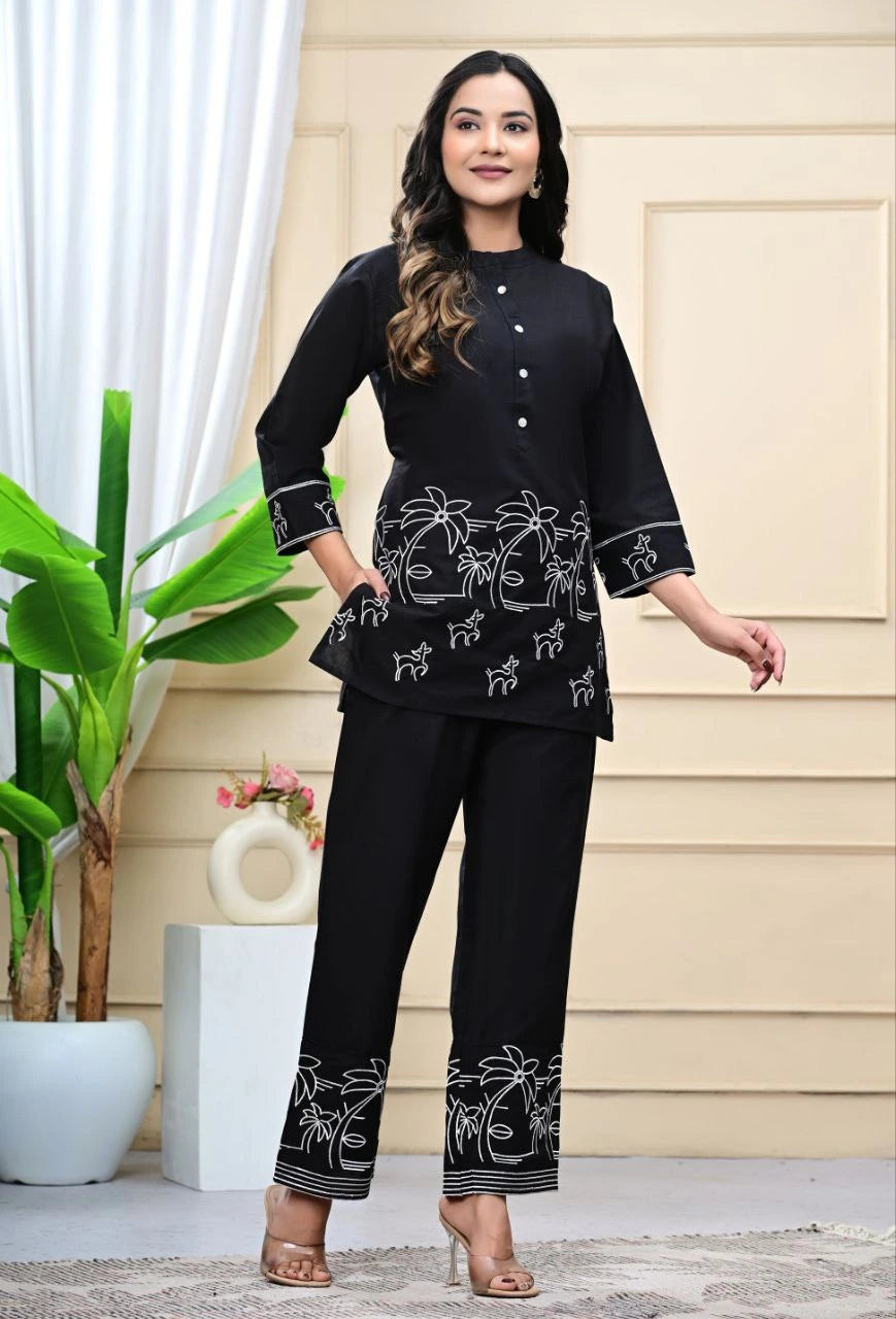 Woman wearing a black outfit with white patterns in a well-lit room.