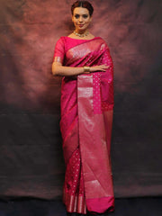 Woman wearing a pink saree with a dark background