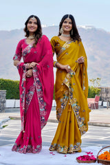 Two women in colorful sarees standing outdoors with a scenic background