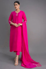 Woman wearing a bright pink traditional outfit with a matching dupatta on a gray background