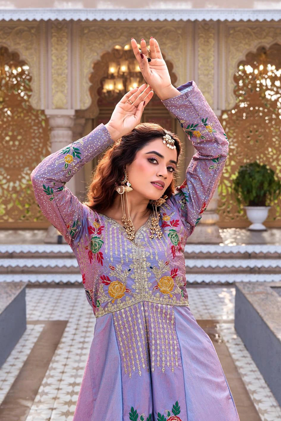 Woman in a traditional embroidered outfit posing in an ornate outdoor setting
