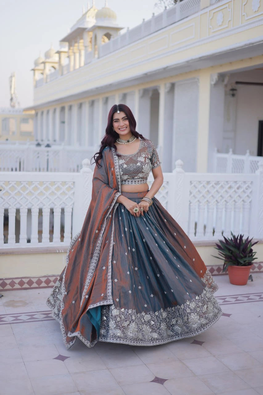 Woman in traditional outfit standing in front of a white building with decorative elements.