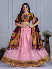 Woman wearing a traditional outfit with a pink lehenga and gold blouse against a gray background