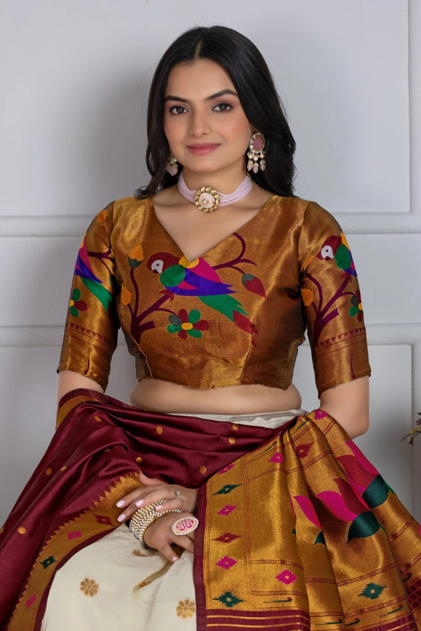 Woman wearing a traditional brown and red saree with intricate patterns against a white background