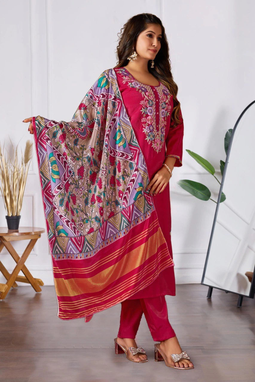 Woman wearing a pink traditional outfit with a patterned dupatta in a room.