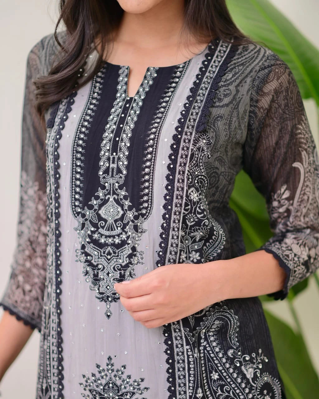 Embroidered traditional outfit with intricate patterns on a neutral background
