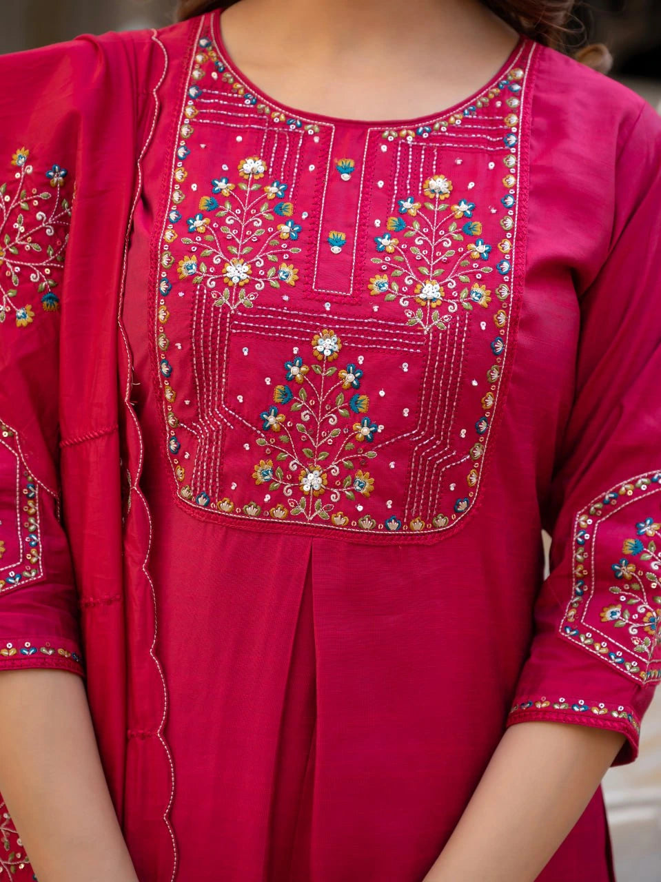 Close-up of a pink embroidered traditional outfit with floral patterns.