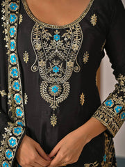 Black embroidered garment with blue floral patterns on a neutral background