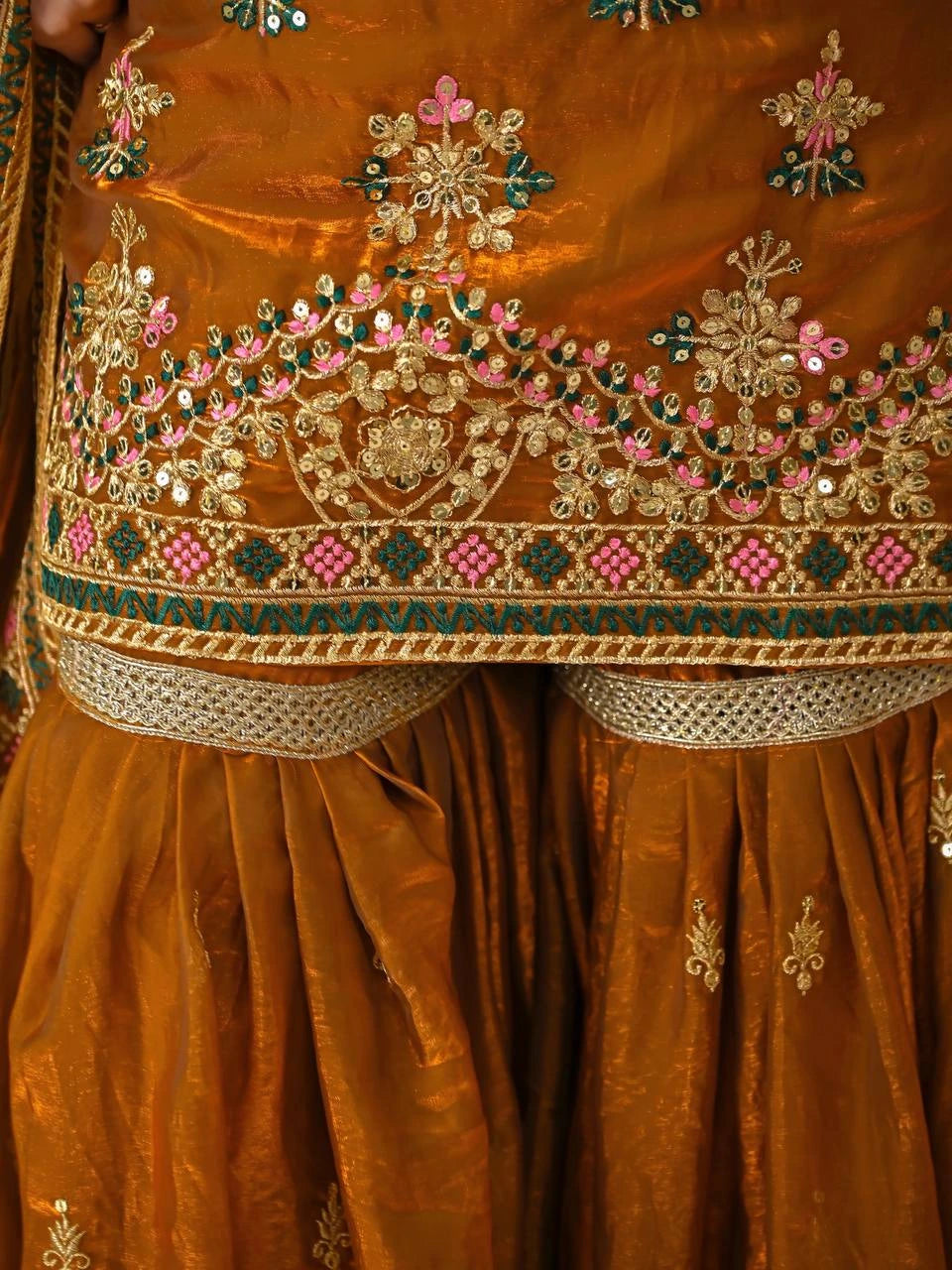 Close-up of a brown embroidered garment with intricate patterns and colors.