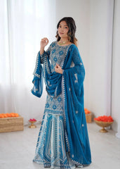 Woman wearing a blue embroidered traditional outfit with a white background