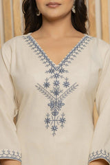 Beige kurta with blue floral embroidery on a plain background