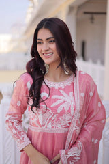 Woman wearing a pink embroidered traditional outfit with a blurred background