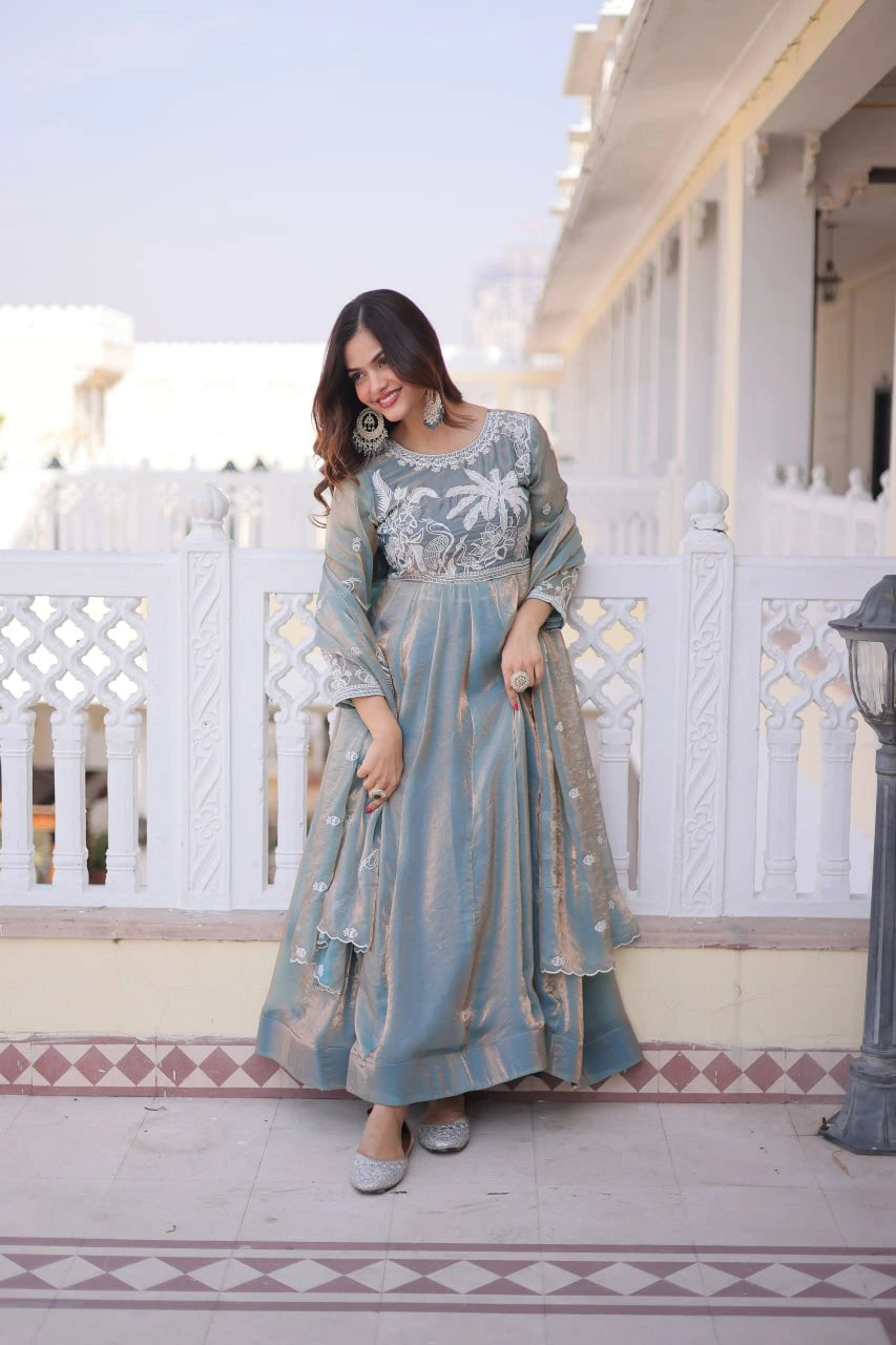 Woman in a traditional outfit standing on a balcony with white railings and architectural details.