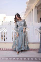Woman in a traditional outfit standing on a balcony with white railings and architectural details.