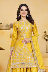 Woman wearing a yellow embroidered traditional outfit on a yellow background