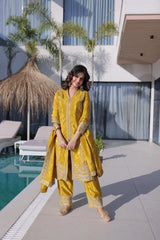 Woman in a yellow traditional outfit standing by a poolside.