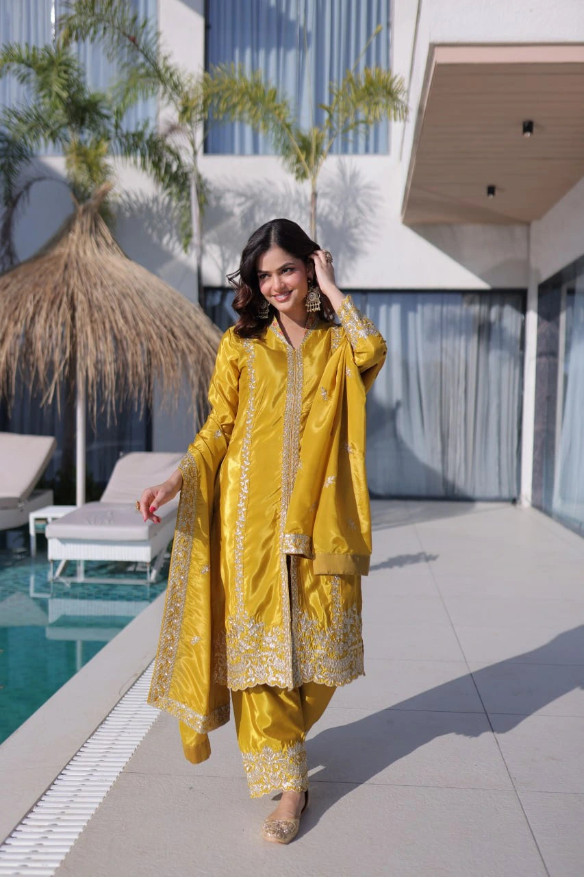 Woman in a yellow traditional outfit standing by a poolside.