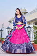 Woman in a traditional outfit with a pink and blue design, standing outdoors.
